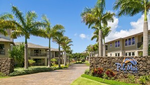 A residential area with a stone wall and a sign for 'Pili Mai at Poipu.' - Pili Mai 12K Spacious 3BR with Central AC (Koloa)