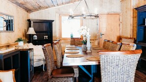 A wooden interior with a dining table, chairs, a chandelier, and a cabinet. - Stunning Chalet at Whispering Springs (Grafton)