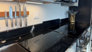 A kitchen with a black countertop, stainless steel appliances, and a knife rack. - Modern, Clean and Cozy 2 Bedroom Duplex in Quiet West Fairbanks (Fairbanks)