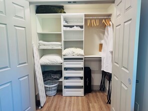 A walk-in closet with open shelves, hanging clothes, and a storage bin. - Modern, Clean and Cozy 2 Bedroom Duplex in Quiet West Fairbanks (Fairbanks)
