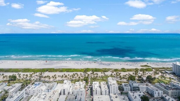 Eine Küstenstadt mit Strand, blauem Himmel und Gebäuden.