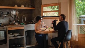 Uma cozinha com mesa de jantar, janela e diversos utensílios.