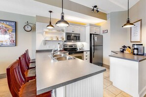 A modern kitchen with a central island, stainless steel appliances, and pendant lighting. - Charming Family Home: Summer Pool, Minutes to BM! (The Blue Mountains)