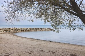 A sandy beach with a rocky breakwater and calm water. - Bright Wintergreen Condo w/ Private Sauna & Golf (The Blue Mountains)
