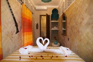Una habitación de hotel con cama, un espejo y un estante con artículos de aseo.