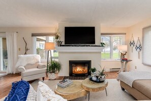 Ein Wohnzimmer mit Kamin, Fernseher und einer Couch.