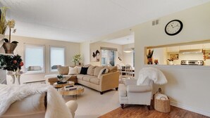 A living room with a beige sofa, a white armchair, a coffee table, and a fireplace. - Cozy & Chic Mountain Getaway | Steps to BM Village (The Blue Mountains)