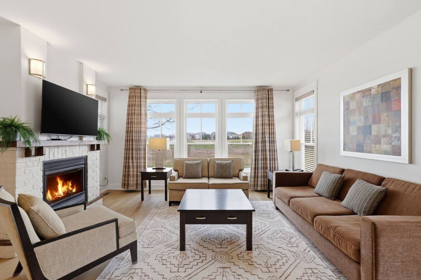 A living room with a fireplace, sofa, coffee table, and a television.
