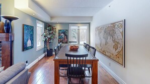 A dining area with a long table, chairs, a potted plant, and artwork on the walls. - Spacious Mountain Walk Home, Steps to Blue! (The Blue Mountains)