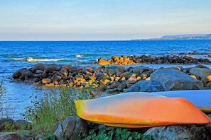 Una costa rocosa con tablas de surf y vista al océano.