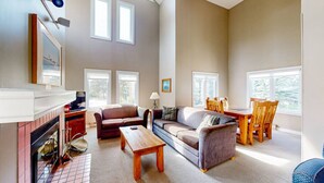 A spacious living room with a fireplace, multiple seating areas, and large windows. - Mountain Side Getaway, Steps to Blue (The Blue Mountains)