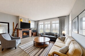 A modern living room with a fireplace, a sofa set, a coffee table, and a television. - Peak to Green Escape: Mountain Views & Golf (The Blue Mountains)
