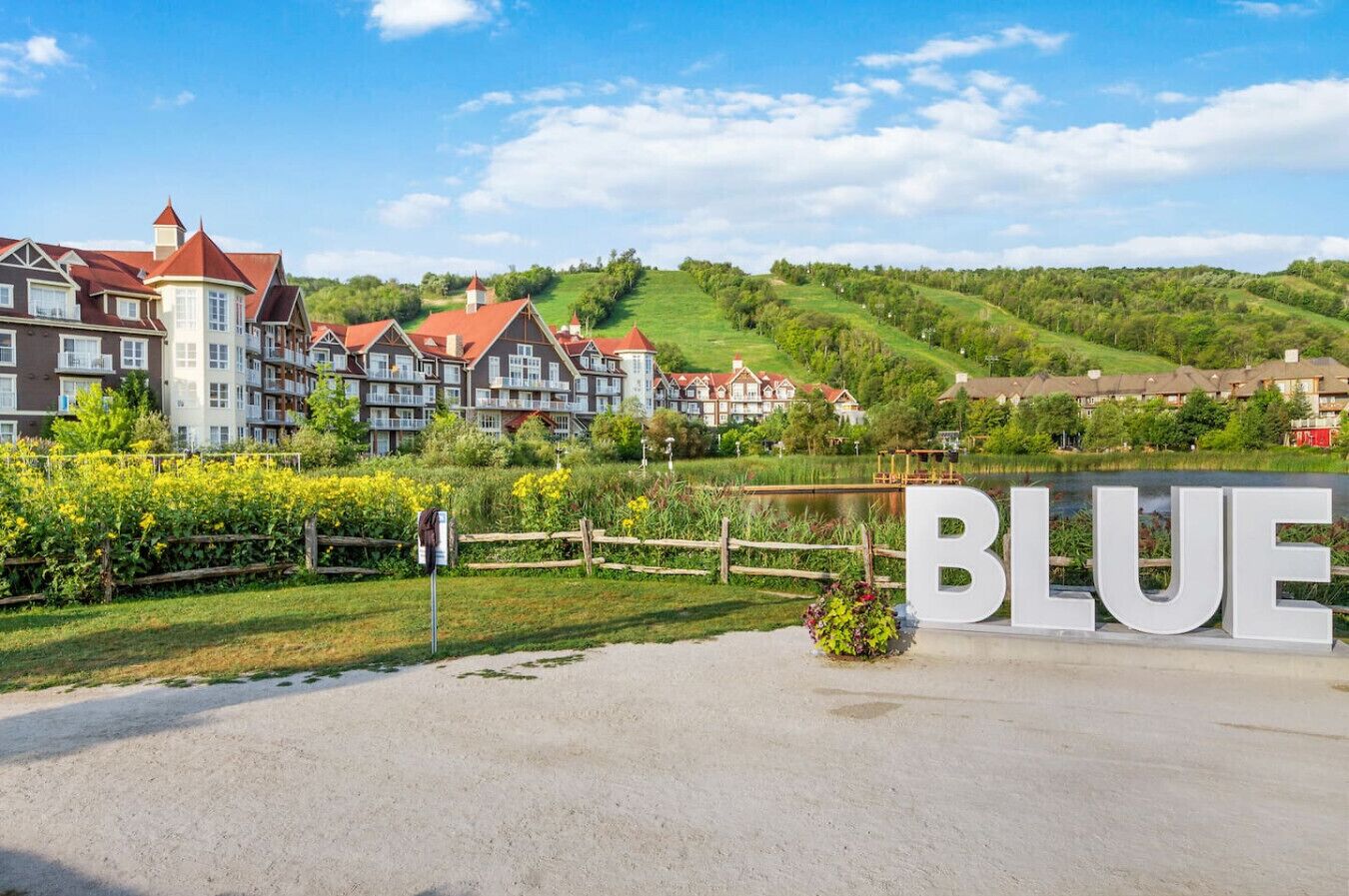 Ein Wohngebiet mit Häusern, einem Schild mit der Aufschrift 'BLUE' und einem Gewässer.