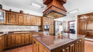 A kitchen with wooden cabinets, a central island, and a built-in oven. - Stunning home in Tahiche with private swimming pool, can be inside or outside (Tahiche)