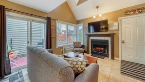 A living room with a fireplace, a television, and a sofa. - Family North Creek Condo w/ Pool, Hot Tub, Tennis! (The Blue Mountains)