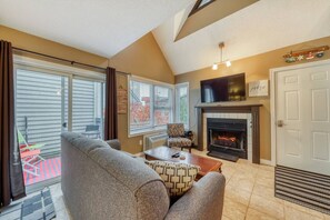 Ein Wohnzimmer mit Kamin, Fernseher und einer Couch.