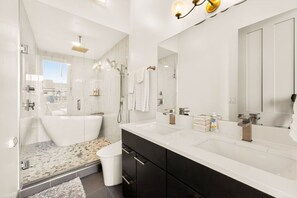 A modern bathroom with a bathtub, two sinks, a shower, and a large mirror. - Luxury 3BR on TQL Stadium & Washington Park (Cincinnati)