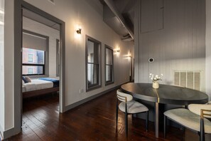 A modern interior with a bed, a dining table with chairs, and a view of the outside. - Luxury 3BR on TQL Stadium & Washington Park (Cincinnati)