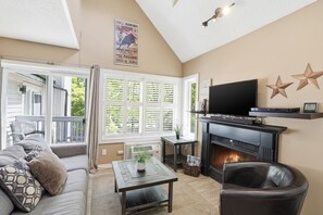 Ein Wohnzimmer mit Kamin, Fernseher und einer Couch.