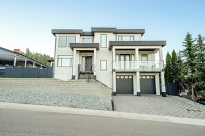 A modern two-story house with a covered driveway, a front entrance, and a garage. - Luxury Okanagan House in heart of Kelowna! (Kelowna)