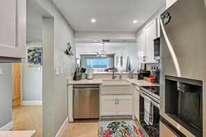 Eine moderne Küche mit Geschirrspüler, Backofen und Blick ins Freie.