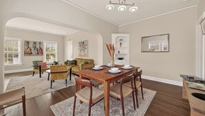 Een eetruimte met een houten tafel, stoelen en een kroonluchter.