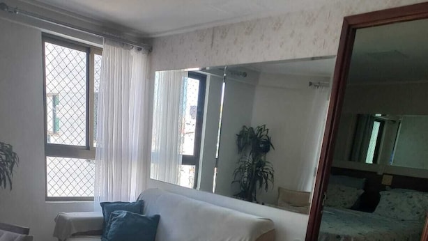 Een kamer met een bank, een klein tafeltje en een bed met een bedovertrek met patroon.
