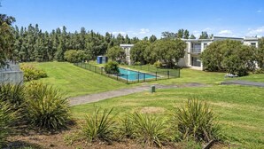 Un quartier résidentiel doté d’une piscine, de pelouses bien entretenues et de maisons modernes.