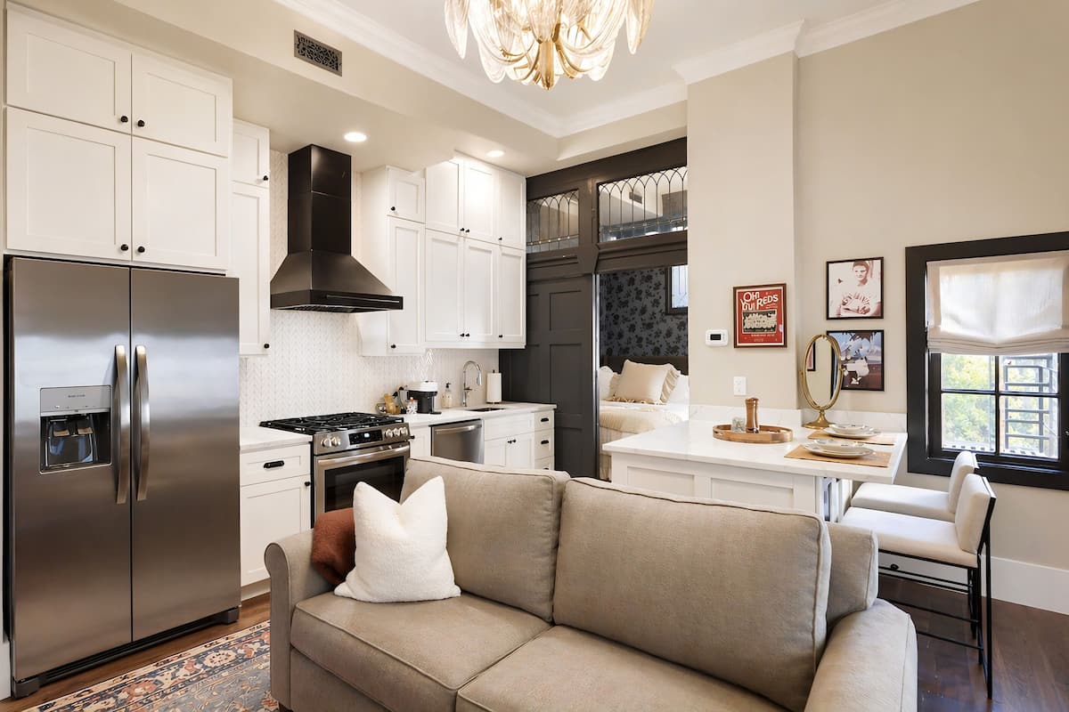 A modern kitchen with white cabinetry, a stainless steel refrigerator, a gas stove, and a built-in oven.