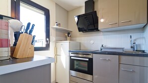 Eine moderne Küche mit Einbauofen, Mikrowelle und einem Fenster für natürliches Licht.