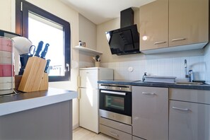 Eine moderne Küche mit Einbauofen, Mikrowelle und einem Fenster für natürliches Licht.