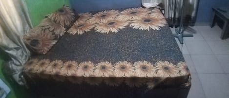 A bed with a patterned bedspread and decorative pillows.