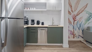 A compact kitchen with a built-in dishwasher, a coffee maker, and a toaster. - Comfy suite near Epic and Universal - free parking (Orlando)