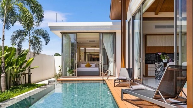 Quarto de hotel moderno com porta de vidro que dá para uma varanda, uma piscina e vista do céu.