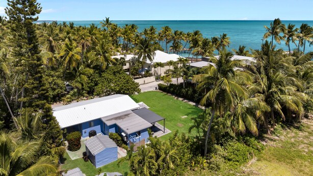 A coastal property with a large house, a lawn, and palm trees. - Surf Shack - Downtown Islamorada 2 Bedroom Beach Bungalow (Islamorada)