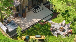 A wooden cabin with a deck, hot tub, and outdoor seating area. - Abode at Luxe Barnhouse, teton views, hot tub (Jackson)