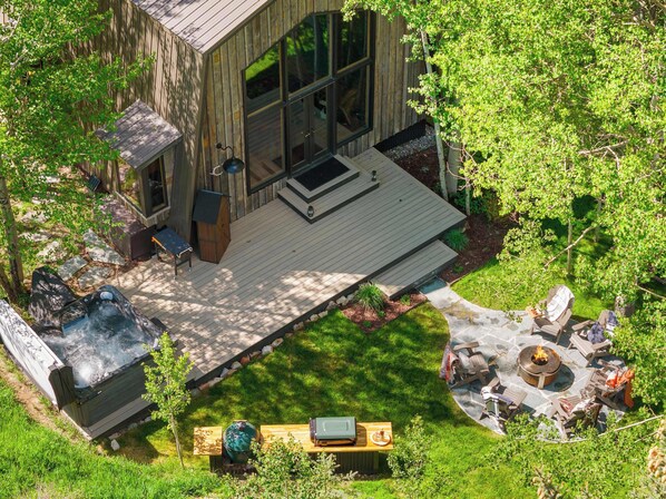 Eine Holzhütte mit Terrasse, Whirlpool und Sitzbereich im Freien.
