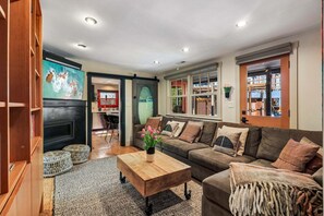 Ein Wohnzimmer mit Sofa, Couchtisch und Kamin.