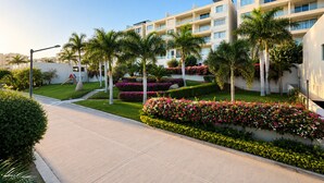 Un hôtel moderne doté d’une cour intérieure, de palmiers et de parterres de fleurs.