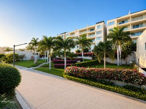 Ein modernes Hotel mit Innenhof, Palmen und Blumenbeeten.