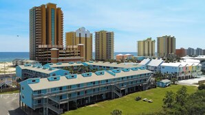 Um complexo hoteleiro costeiro com vários edifícios altos, um prédio central com teto azul e vista para o oceano.