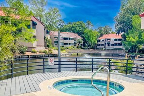 A swimming pool with a deck, a no-fishing sign, and buildings in the background. - Lagoon Views; Community Pool, Hot Tub & Cabana; Dog-Friendly; Walk to Shelter Cove Marina & Shops! (Hilton Head Island)