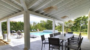 An outdoor covered patio with a pool, lounge chairs, and a dining area. - Villa Ambre - BULLY - Gîte (BULLY)