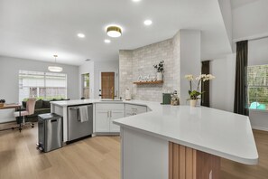 A modern kitchen with a white countertop, a built-in oven, and a wooden cabinet. - Blissful Retreat Savannah/PET Friendly/3 BD/2 BATH (Savannah)