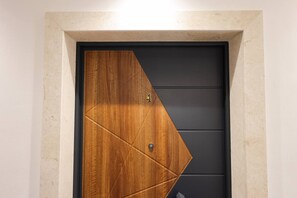 A door with a geometric design, a number '4' on the door, and a small lock. - Cozy Apartment 04 in Durr s (Durrës)