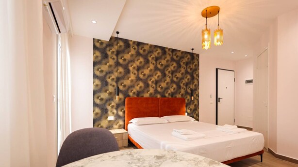 Ein modernes Hotelzimmer mit einem großen Bett, einem Marmortisch und einer Wand mit Muster.