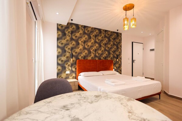 A modern hotel room with a large bed, a marble table, and a patterned wall. - Cozy Apartment 04 in Durr s (Durrës)