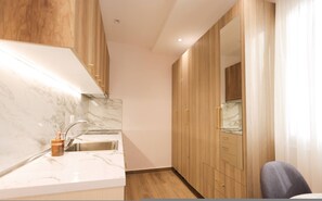 A modern kitchen with marble countertops, a stainless steel sink, wooden cabinets, and a built-in oven. - Cozy Apartment 04 in Durr s (Durrës)