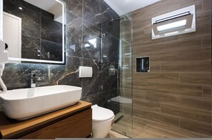 A modern bathroom with a white sink, a mirror, a glass shower enclosure, and a toilet. - Cozy Apartment 02 in Durr s (Durrës)