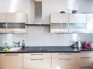 Een koelkast, een oven, kookgerei, borden en bestek